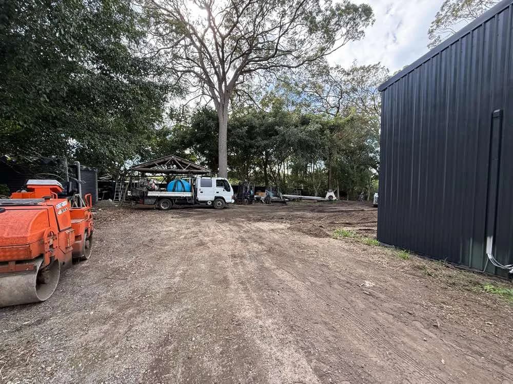 An untreated gravel yard with ruts, potholes and loose stone